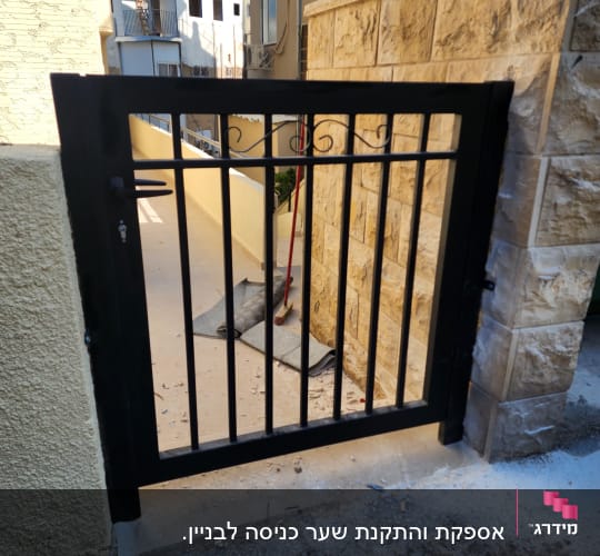 שער מתכת שחור עם עיטור עליון